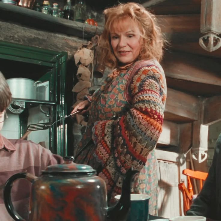 Molly Weasley from Harry Potter wears colorful, flowy crochet sleeves in a scene at the Weasley's house.